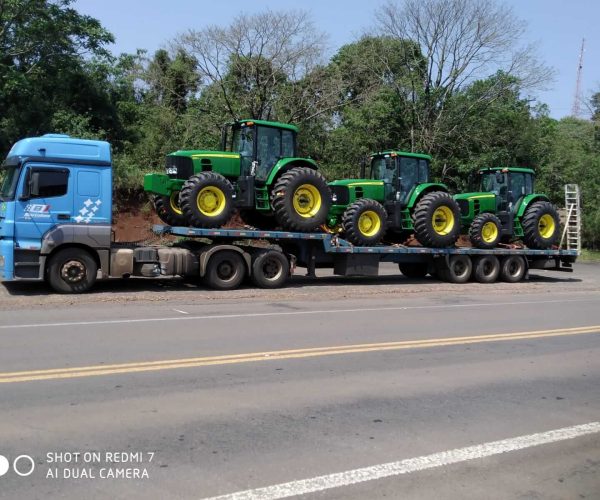 camion trasportando carga de tractores